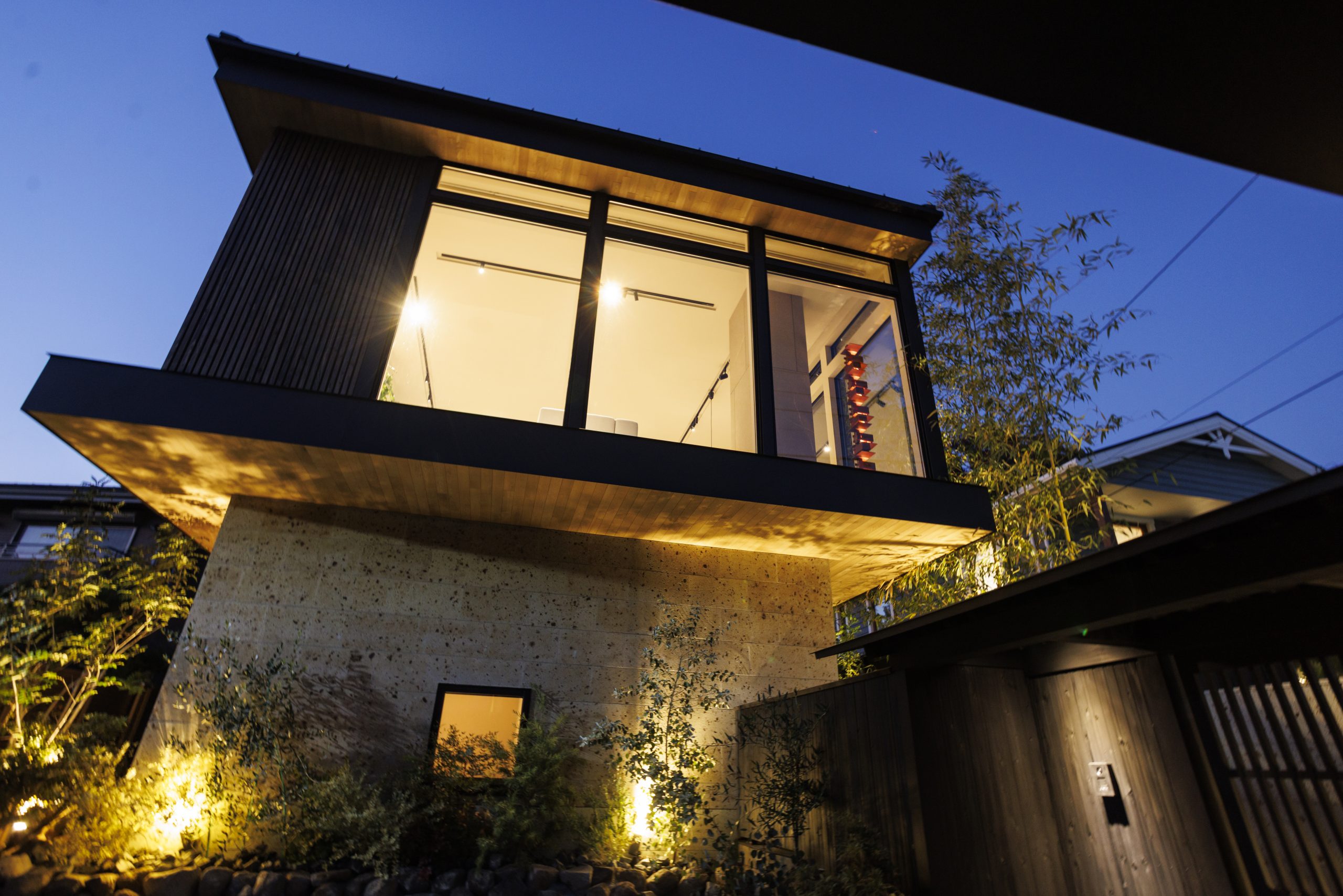 オーバーハングと植栽がファサードを強調する